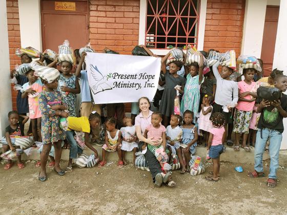 Ellijay native Dedra Key, sitting in front, is shown with some of the 575 Haitian children who now attend school and are fed with funding from her nonprofit, Present Hope Ministry. 