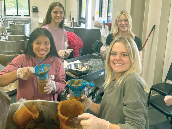Bailey Baldwin, Erica Reynoso, Lyla Engle and Katelyn Campbell put apple butter made by their class into jars at the Gilmer County Cannery. (Contributed photos)