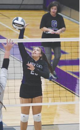 Gilmer High’s Grace Bramlett sends the ball over the net versus White County as coach Maria Huelsman observes.