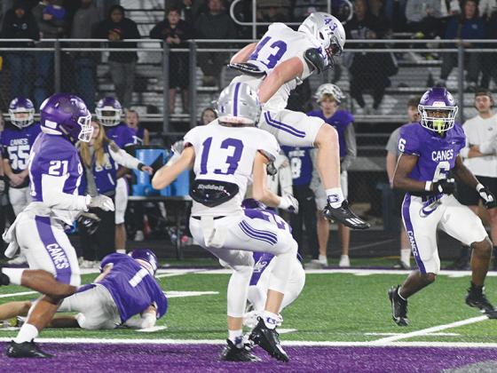 Gilmer High School freshman halfback Douglas Callihan leaps over a Monroe Area defender during last Friday’s second round game of the Class 3A playoffs. He rushed for 110 yards on eight attempts and caught two touchdown passes for 16 yards.