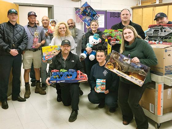 Representatives of Gilmer Fire and Rescue, Ellijay Fire Department, Ellijay Elementary School and Gilmer County Schools are shown with a delivery of toys that was part of this year’s Ellijay-Gilmer Firefighters Kids Christmas effort. Pictured, from left, back: Rylan Cochran, Alton Guidry, Dwayne McPherson, Andrew Mabry, Dr. Melinda Fonteboa, Tommy Vandiver, Katherine Evans, Sam West and Dustin Lovell; front: Mike Dempsey, Emerald Goble and Haley Gaddy. 