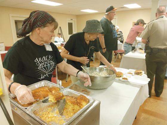 Donna Carlsen, left, and Sylvia Negri, right, were among the members of Ellijay Hope Lutheran Church who put together barbecue plates last week at a special lunch for the county’s emergency response personnel. Hope Lutheran wanted to show its appreciation to local fire, police and 911 employees after a recent successful response to a car accident that involved a church member. 