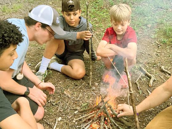 Mountain Wisdom campers learn how to build a fire from scratch during a past session of the electronics-free, back-to-nature camp. 
