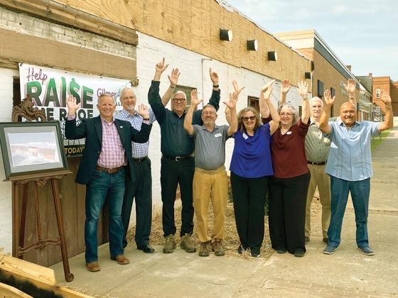 District 7 Rep. Johnny Chastain, left, “raises the roof” alongside Gilmer Arts staff, board members and supporters during the official announcement of a $100,000 state grant that will help turn the pictured Dalton Street building into a new art gallery. Above, from left: Chastain, John Rathbone, Ben Chin, Joe Cantwell, Jan Dappen, Pam Burns, Len Tucker and Terry Ellis.