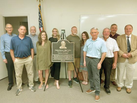 Pictured, from left, board member Hubert Parker, board member Ricky Wimpey, board member Tony Whitaker, wife Halena Gibbs, daughter Holli Gibbs, son Matt Teague, daughter-in-law Whitney Teague, board chairman Billy Rowe, board member David Westmoreland, former board member Greg Teague and water authority director Gary McVey. 