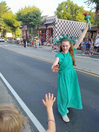A pretty Lady Liberty greets a youthful parade watcher on the Fourth of July. (Photo by Mark Millican)