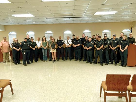 Gilmer County Commissioners and fire department members are joined by Eric Maddox’s widow, Amy Jo, and daughter and son, Bethany and Timothy, following a vote to name fire station 14 in Maddox’s honor. 