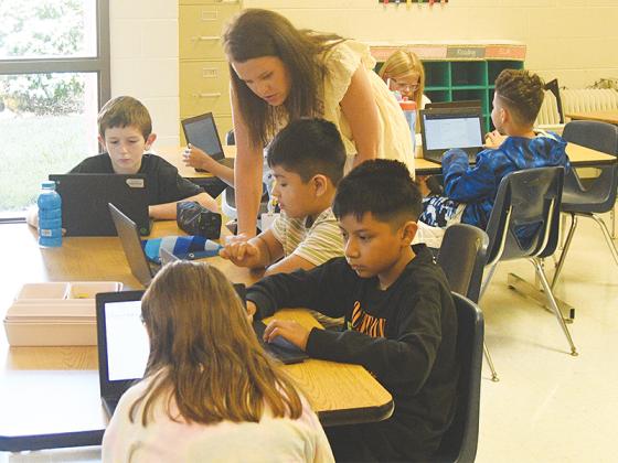Fifth-grade teacher Kali Lambert assists students with checking their email.