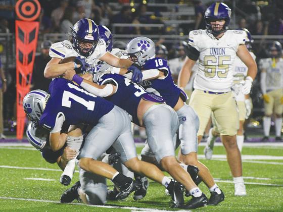 Robbie Bills/Sports Editor Gilmer defenders Memphis Lewallen (18), Peyton Chancey (34), Jack Puckett (71) and Blane Banks stop Union County’s Connor Schuknecht for a loss last Friday.