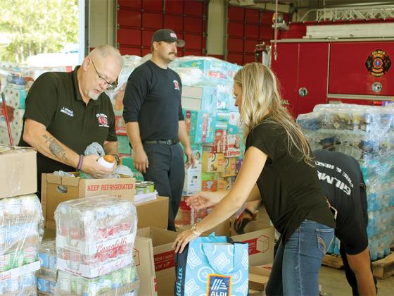 Jackie Cochran, John Gillen and Amber Stokes  sort supplies before loading a pallet bound for south Georgia.
