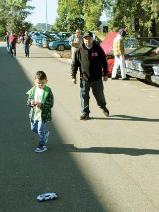 Jackson Rangel drives his remote control vehicle as Miguel Rangel watches him display his skills at the car show held by the Apple Country Classic Auto Club Inc. of Ellijay during the first weekend of the Georgia Apple Festival in Gilmer County.