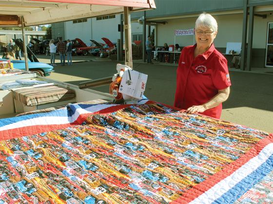 Linda Garland spreads out the quilt she created for the the Apple Country Classic Auto Club Inc. of Ellijay car show raffle.
