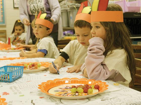 Kolton McClenathan, Konner Petit and Anna Nix get in some coloring while eating in Carol Perry’s class.