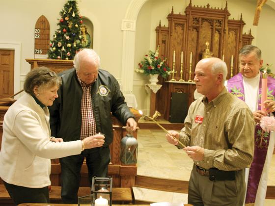 Attendees at a past Bethlehem Peace Light ceremony at Good Samaritan Catholic Church in Ellijay get their candles and lanterns lit in order to carry the flame to their homes and/or respective churches. From left are Ginger Hussian, Richard Byers, organizer Jack Planchard and Monsignor Jaime Barona, a retired priest from Gainesville. This year, the flame will be shared on Saturday, Dec. 21, at 10 a.m. at Hope Luthern Church south of Ellijay. The public is invited.