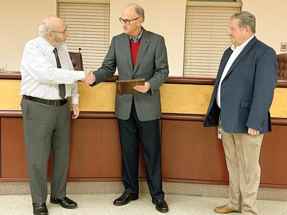 Gilmer County Post Commissioner Hubert Parker (center) was honored with a plaque at his final regularly scheduled meeting by Gilmer County Chair Charlie Paris and Post Commissioner John Marshall.