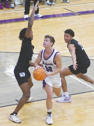 Gilmer junior Boston Teague splits two Calhoun Yellow Jackets as he makes his way to the basket last Friday.