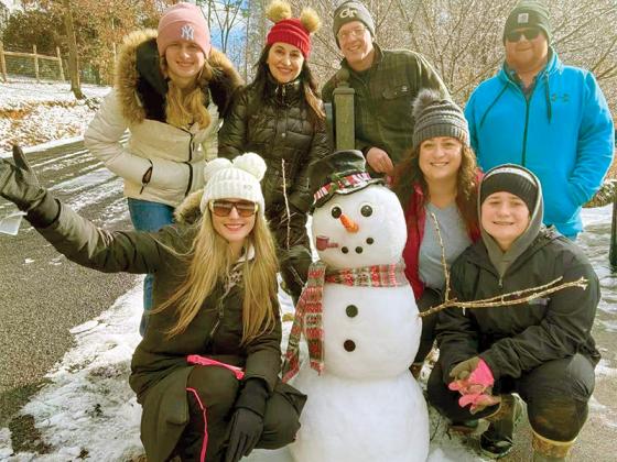 The Keith family poses next to their snowman creation in Ridgeview Trail.