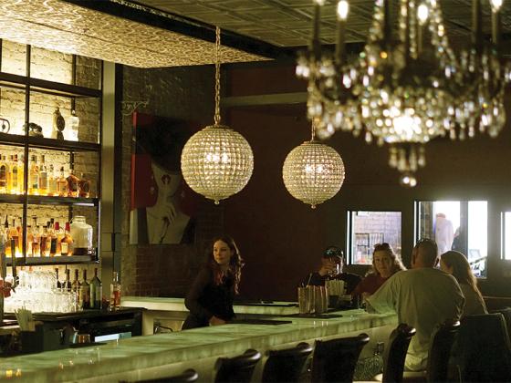 Bartender Laura Rossi serves guests at the Door, Ellijay’s first speakeasy featuring unique cocktails, light bites and atmospheric lighting.