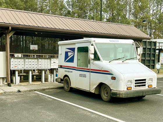 Mail carrier delivers to a cluster box unit in the Coosawattee River Resort.