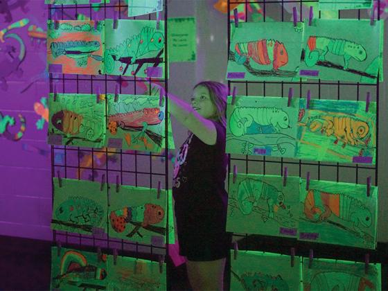 2nd grader Aria Daley admires her glow art.