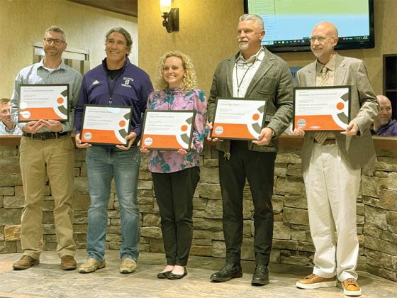 Representatives from each school in the district accept certificates for their Cognia Systems Accreditation at the GCSS board meeting March 17.