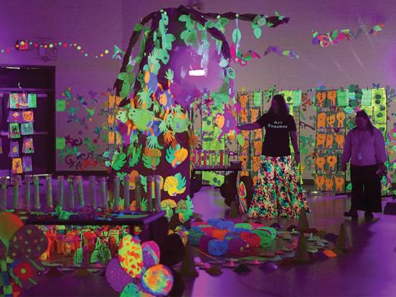 Art teacher and Glow Show organizer Misti Foster prepares the gym before families arrive. 