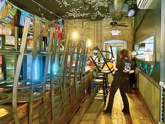 Server Brooke Swofford works to get River Street Tavern ready to open for lunch. She said she has to work 50 hours a week right now, due to short staffing. 