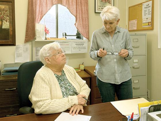 Volunteer counselors Bonnie Wells and Cheryl Worley discuss how best to serve their client in the Faith, Hope and Charity benevolence office.  