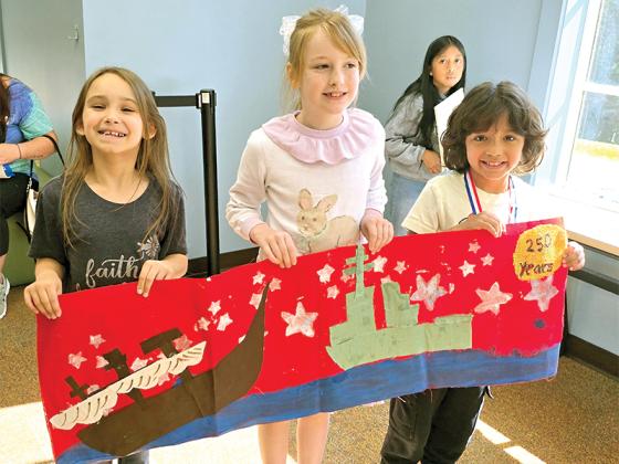 2nd graders Arabella Collins, Maggie Edwards and Alfredo Godina with their banner that placed 2nd nationally in the Daughters of the American Revolution Junior Citizen Art Contest. (Courtesy of Misti Foster)