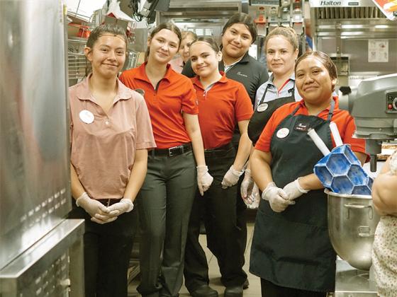 Staff members work in the new centerline kitchen to prep and cook menu items at Chick-fil-A’s friends and family night April 22.