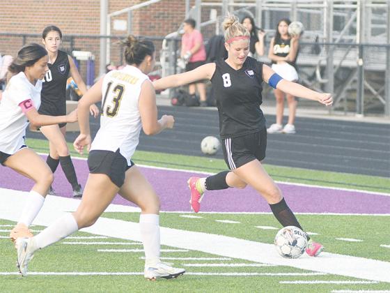 Lady Cat senior Sophia Lykins (8) tracks the ball down before sending it to Gilmer’s attackers.