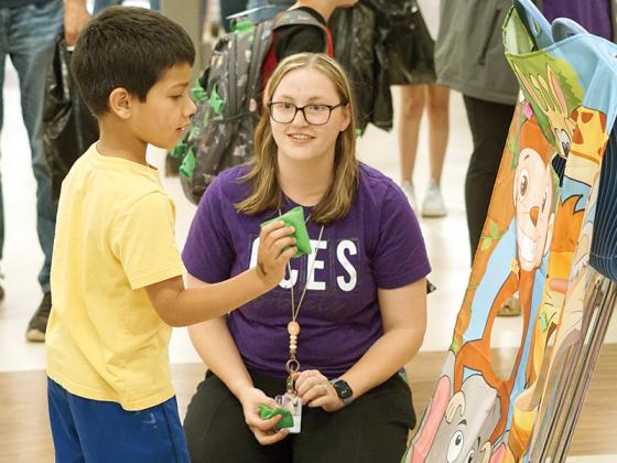 Teachers, community organizations and student groups set up booths around Gilmer High School, letting attendees participate in games, pick up books for all ages and win prizes. Clear Creek Elementary teacher Courtney Trecartin played a word association bag toss game with Oliver Salgado.