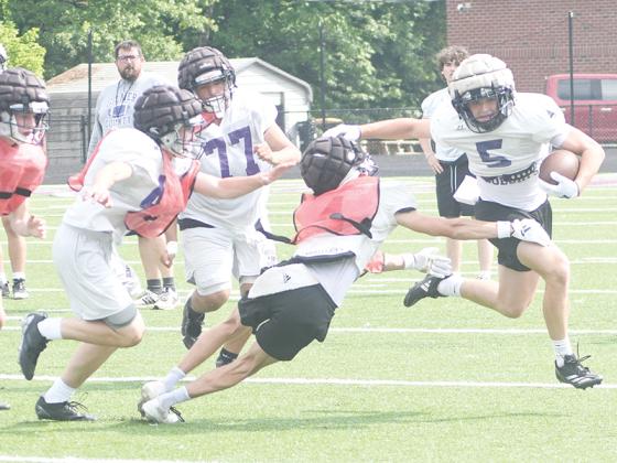 Gilmer’s Hunter Britain (5) uses a stiff arm to get around the corner on the final day of spring practice.