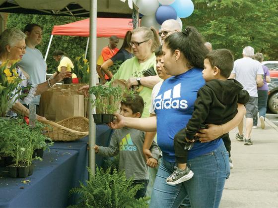 Resident Maria Garcia Landaverde grabs her tomato plants alongside her children.