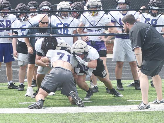 Gilmer High offensive linemen practice double-team blocking under the watchful eyes of coaches Ashley DeWitt and Drew Gaddy.