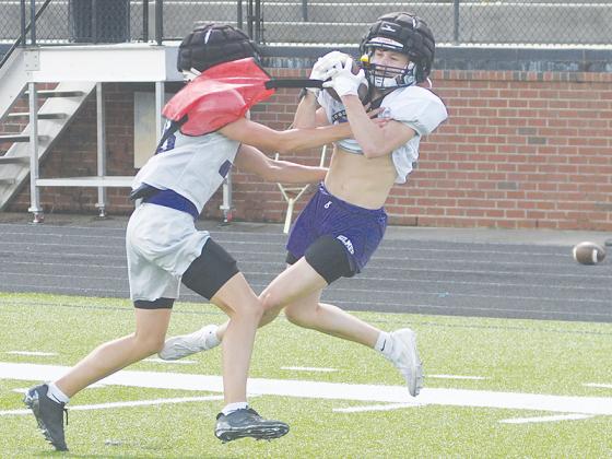 Gilmer High School receiver Nate Wiseley hauls in a long pass from quarterback Bo Cronic at Monday’s practice.