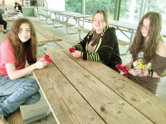 American Legion Family Junior Leadership Camp attendees, from left, Aubrey, 12, Jasmine, 16, and Breana, 12, show the poppies they created to give to their parents at an end-of-camp ceremony. 