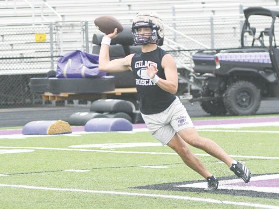 Gilmer High quarterback Bo Cronic passes after rolling to his left at Tuesday’s practice.