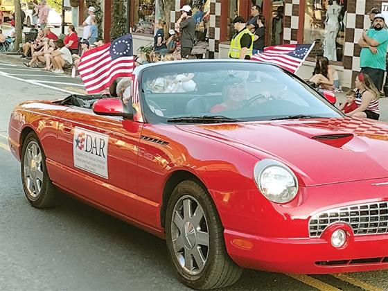 Susan Noles drives and Judy Price rides shotgun in the 2024 Fourth of July Parade in downtown Ellijay. Both are members of the National Society of the Daughters of the American Revolution, Captain James Kell Chapter. 