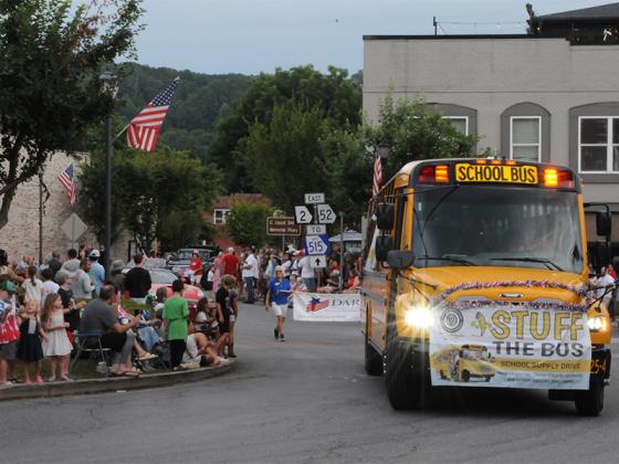 The Optimist Club’s Stuff the Bus event takes part in the July Fourth parade.