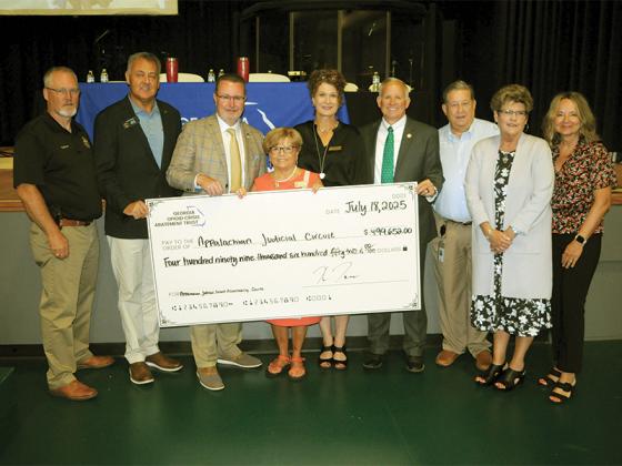 State, local and judicial leaders hold up a check for nearly half a million in grant funding for accountability courts in northwest Georgia. From left, Pickens County Sheriff Donald Craig, State Senator Steve Gooch, Department of Behavioral Health and Developmental Disabilities Commissioner Kevin Tanner, Judge Brenda Weaver, Judge Alison Sosebee, State Representative Johnny Chastain and other state and local leaders.