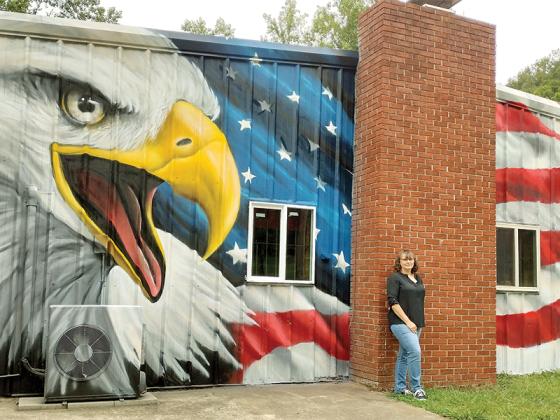 Dawn Lade of the American Legion Post 82 Auxiliary stands in front of the new mural she had a vision for at the facility on Legion Road. The muralist from South Carolina who did the patriotic work wishes to remain anonymous, she said. 