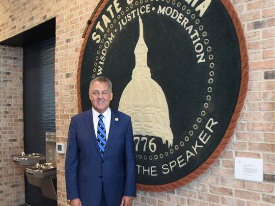State Senator Steve Gooch stands in front of a rug from Speaker David Ralston’s office at the State Capitol. Ralston was honored by UNG with a building named after him on the Blue Ridge campus.