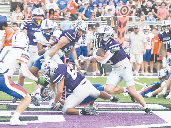 Gilmer High’s Jamie Bautista (63) pancakes a Northwest defender as fellow senior Hunter Britain (5) picks his way through the Bruins defense. Britain rushed for 55 yards to go with 53 receiving yards. Defensively, he recovered a fumble and made five total tackles. 