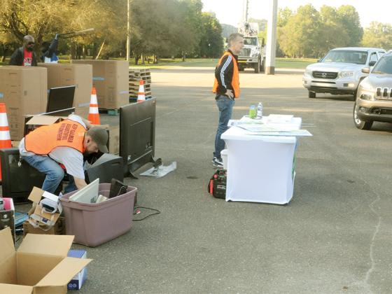 Patrick Cobb, left, and Terrill Carlson, right, work together during Keep Gilmer Beautiful’s recycling event.