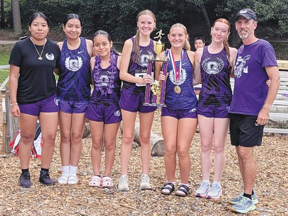 Head coach Tommy Jones joins the second-place Lady Cat cross-country team following last Thursday’s nine-team meet. From left are Jennifer Mateo, Evelyn Martinez, Braelyn Nolasco, Jayla Walker, Ella Schwartz and Lauren Smith.
