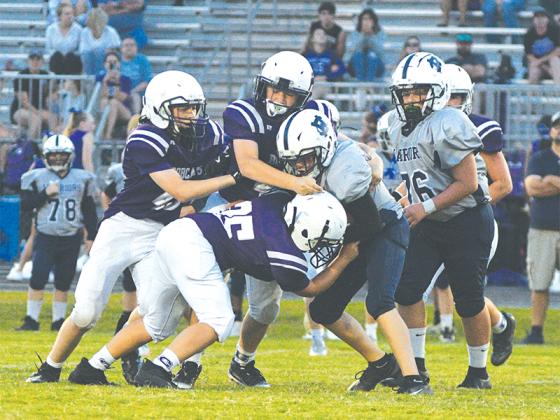 Seventh graders Kylan Merrell (35), Gunner Banks (43) and Jordan Wheeler team up to make a tackle to hold White County short of a first down in the fourth quarter last Wednesday.