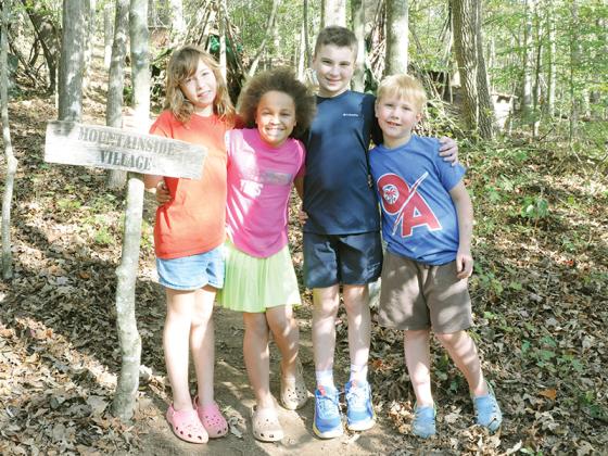 Gilmer county kids show off Mountainside Village, the town they’ve built together. From left are, Evi Lacey, Harvey Bogue, Carter Bogue and Haddon Lacey. 