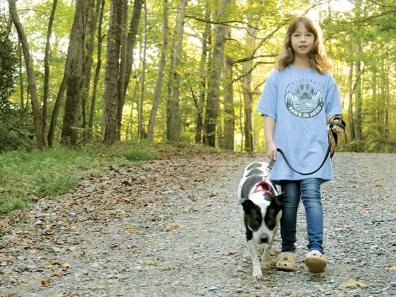 Evie Lacey takes a walk with Shania, a dog at the Gilmer County Animal Shelter.