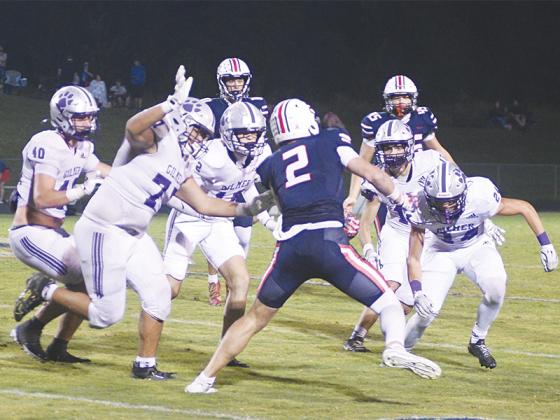 From left, Gilmer High defenders Robert Pim (40), Kevin Olea (77), McCoy Sutton (12), Bo Cronic (17) and Landon Hamby (24) corral a Heritage running back last Friday. 